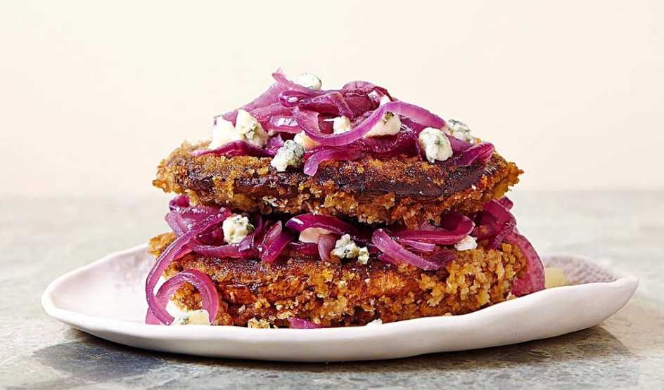 A close-up view of crispy portobello with caramelized onion and blue cheese on a plate