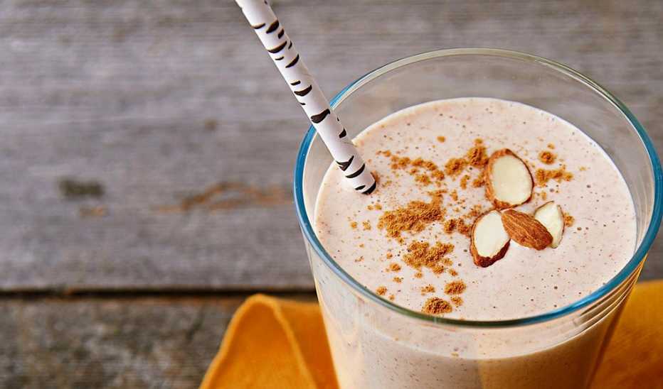 A close-up view of almond butter and banana protein smoothie in a glass