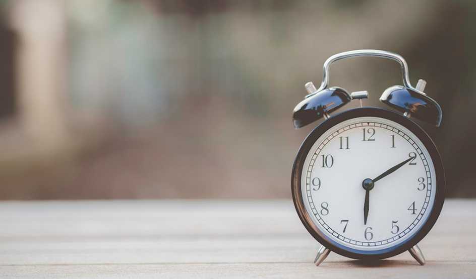 Retro alarm clock sitting on wooden table